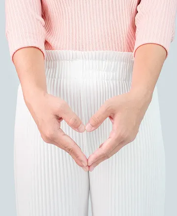 下腹部の前で手を添える女性のイメージ写真